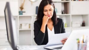 A person looking at a document with a worried expression on their face